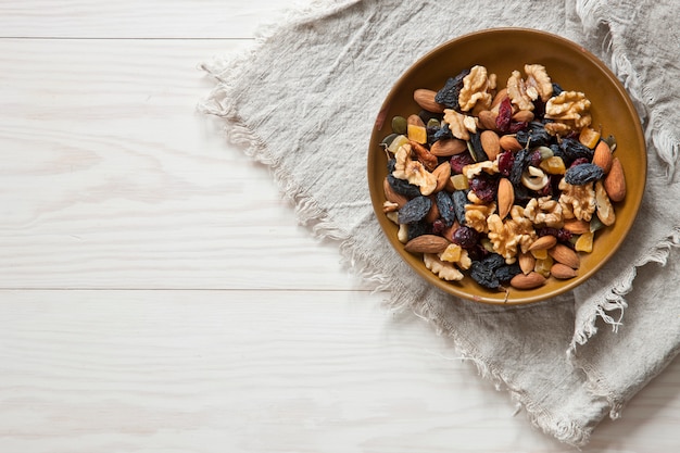 Nuts and dried fruits on white wooden background. Top view, close up. Autumn concept