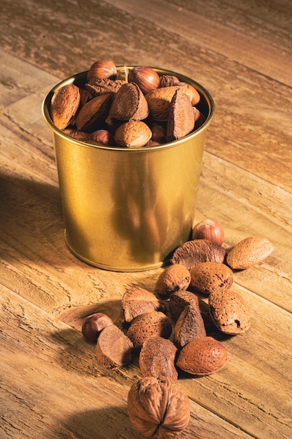 Nuts in a metal decorative bucket on wooden table