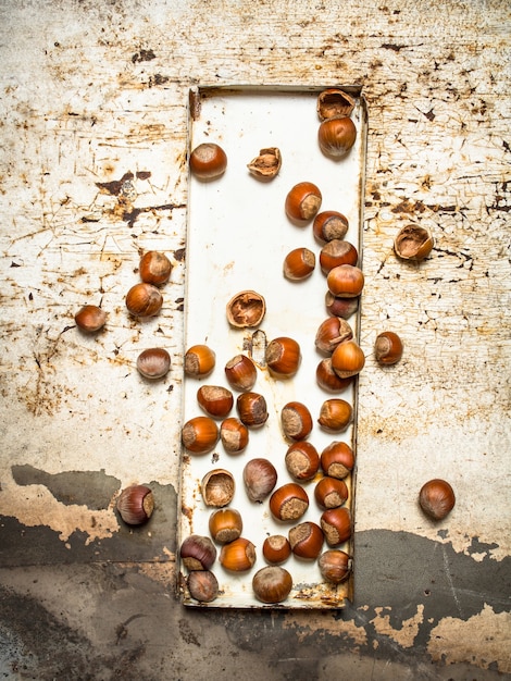 Nuts on the old tray. On rustic background.