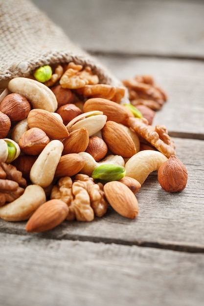 Nuts of various varieties spill out from a wooden plate