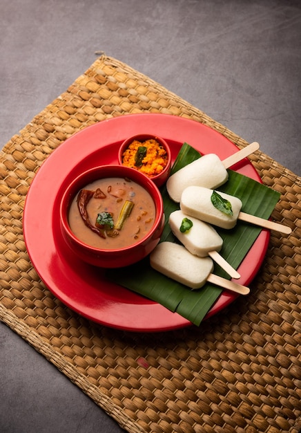 Nutteloze lolly of idli-snoep met stok geserveerd met sambar en chutneyZuid-indiaans ontbijt