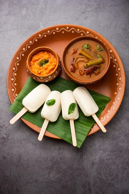 Nutteloze lolly of idli-snoep met stok geserveerd met sambar en chutneyZuid-indiaans ontbijt