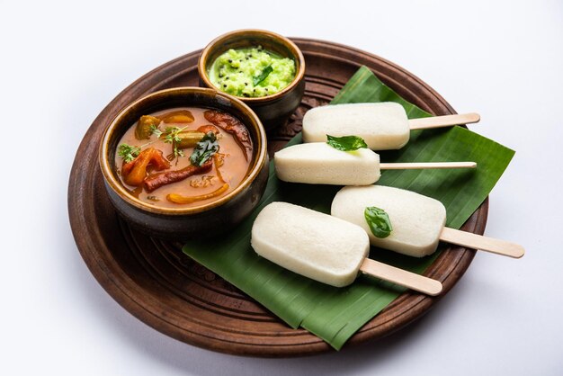 Nutteloze lolly of idli-snoep met stok geserveerd met sambar en chutneyZuid-indiaans ontbijt