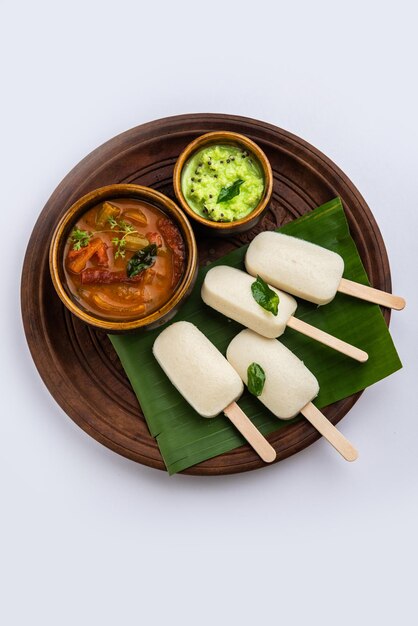 Nutteloze lolly of idli-snoep met stok geserveerd met sambar en chutneyZuid-indiaans ontbijt