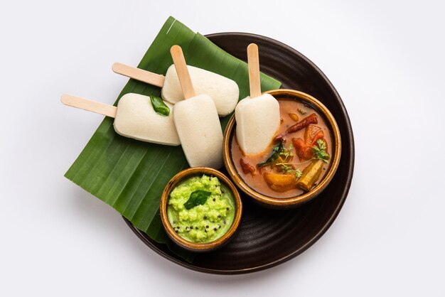 Nutteloze lolly of idli-snoep met stok geserveerd met sambar en chutneyZuid-indiaans ontbijt