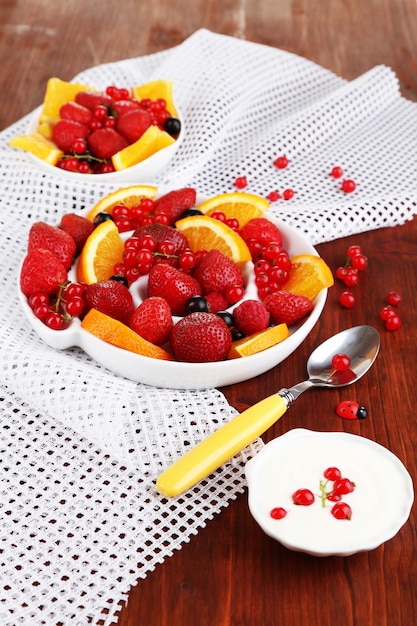 Nuttige fruitsalade in plaat op houten tafel close-up