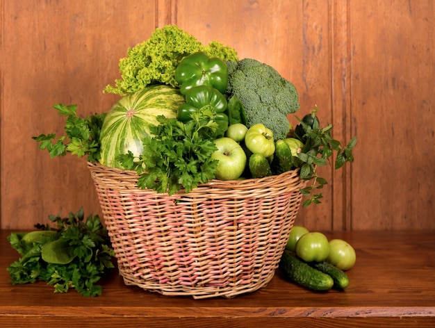 Nuttige groene groenten in de mand op een houten ondergrond