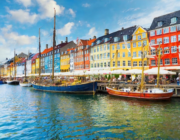 Photo nyhavn area of popular bar and restaurant at beautiful blue sky with colorful facades of old houses ...