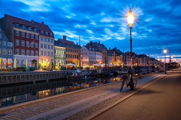 Nyhavn with colorful facades of old houses and old ships in the Old Town of Copenhagen, capital of Denmark.