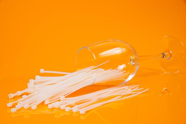 Nylon cable ties in glass in jar in bucket on orange background