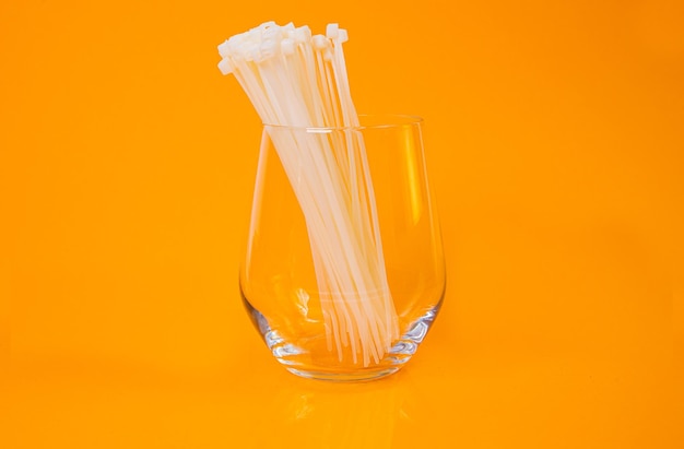 Nylon cable ties in glass in jar in bucket on orange background