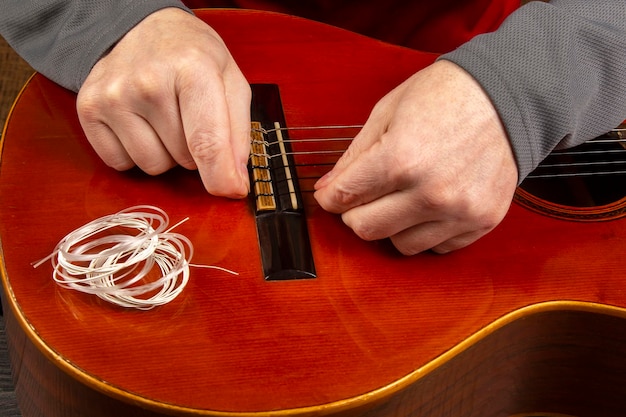 Nylon snaren wisselen op een zessnarige klassieke gitaar. instructie voor muzikant