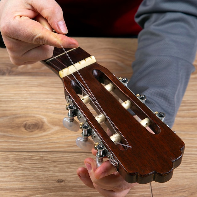 Foto nylon snaren wisselen op een zessnarige klassieke gitaar. instructie voor muzikant