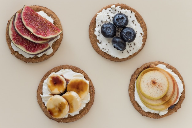 Oat cakes with different toppings on beige background Healthy dietary snack