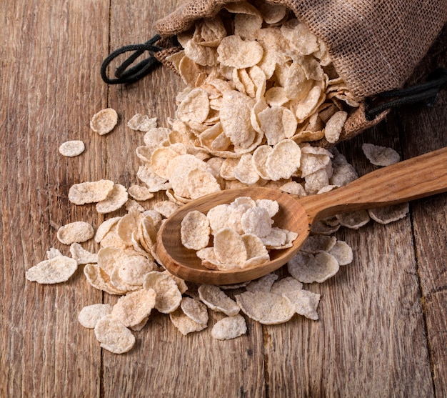 Oat cereal in burlap sack on wooden surface