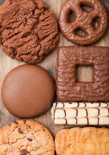 Выбор овсяного и шоколадного печенья на деревянной доске на каменной кухне