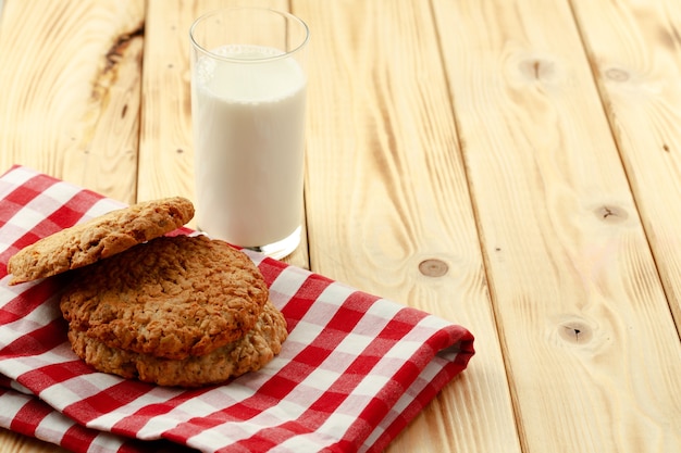 Oat cookies and glass of milk on wooden table