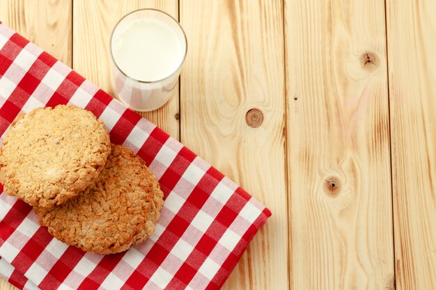 Oat cookies and glass of milk on wooden table