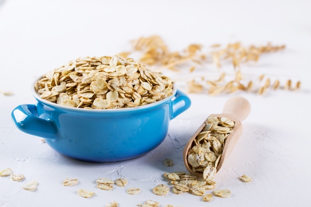 Oat flakes in blue bowl on the kitchen table