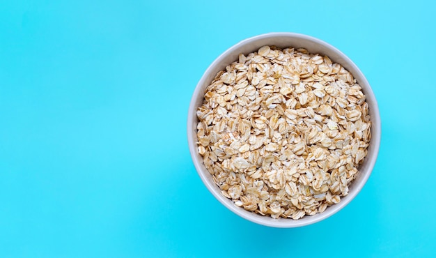 Oat flakes in bowl on blue