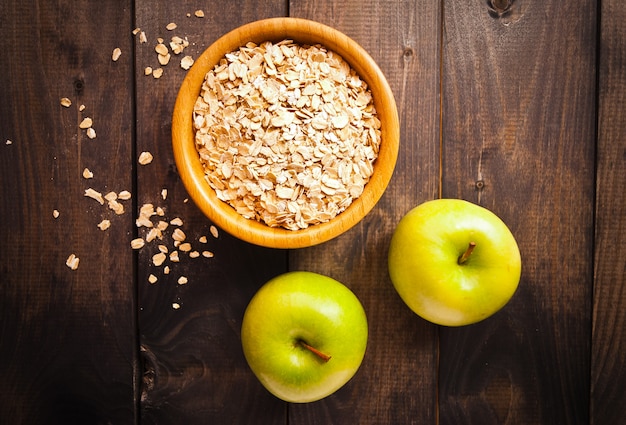 Oat flakes in bowl and two apples