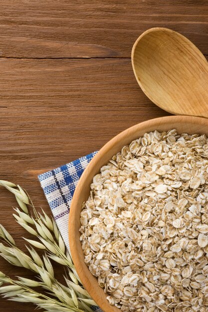 Oat flakes in bowl on wooden surface