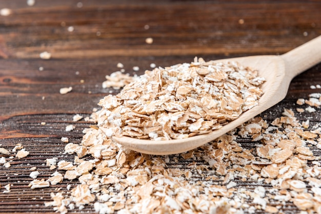 Oat flakes on dark wood.