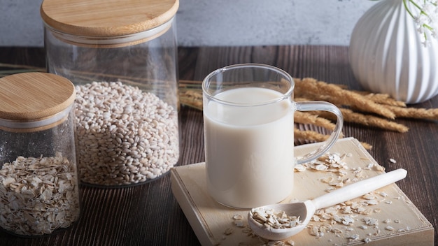 Oat flakes on a glass bowl and jug of milk