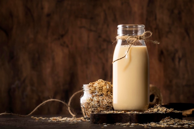 Fiocchi d'avena latte non lattiero-caseario bevanda a base vegetale alternativa in legno di vetro rustico tavolo da cucina spazio copia