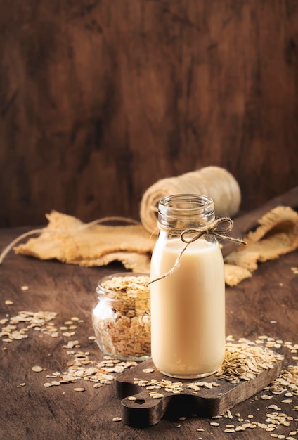 Fiocchi d'avena latte non lattiero-caseario bevanda a base vegetale alternativa in legno di vetro rustico tavolo da cucina spazio copia