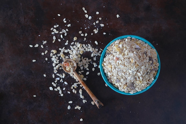 Oat flakes uncooked in a green bowl on rustic table Healthy food for breakfast