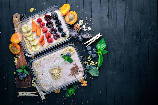 Oat flakes with yogurt and fruits Healthy Diet Food Lunch Boxing On a black wooden background Top view Free space for text