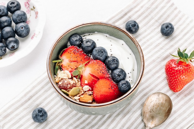 Oat muesli with yogurt and fresh berries in a bowl for a healthy breakfast