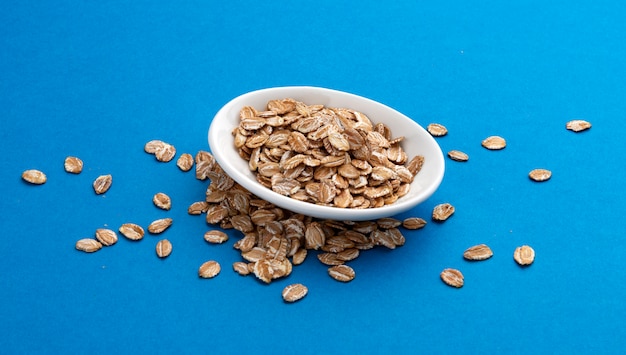 Oat rye flakes on blue color 