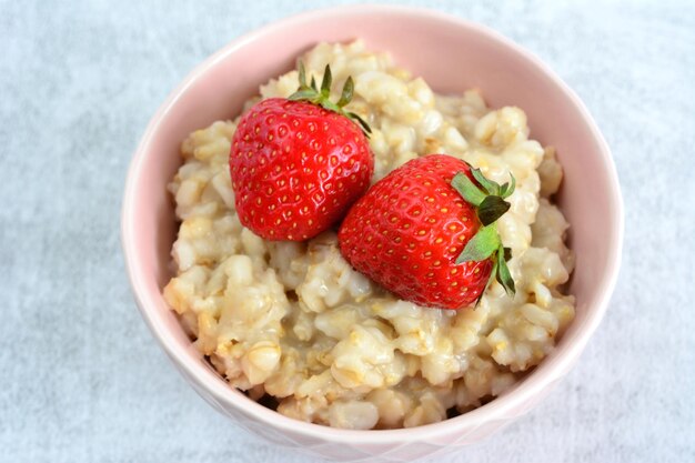 oatmeal in bowl decorated with strawberry close up