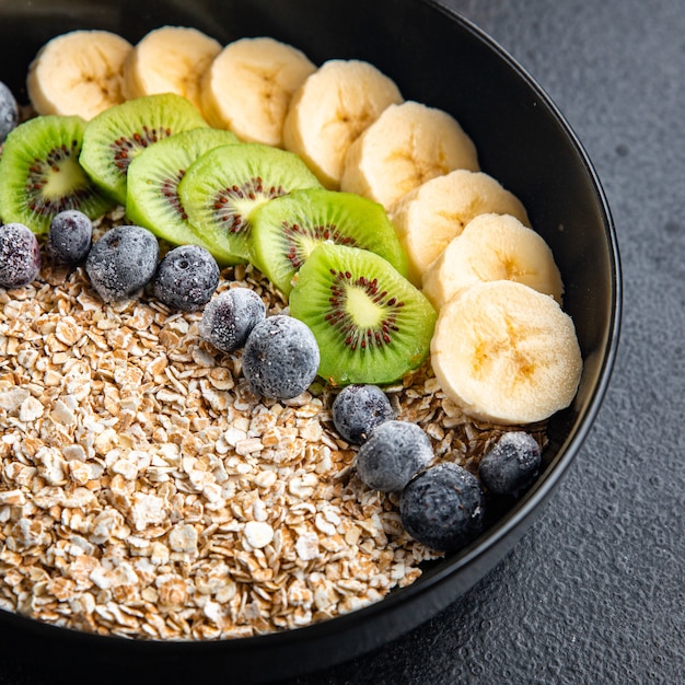 oatmeal bowl fruit banana kiwi berries blueberries ready to eat meal snack on the table