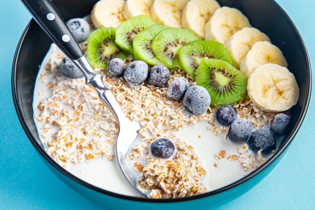 oatmeal bowl fruit banana kiwi berries blueberries ready to eat meal snack on the table