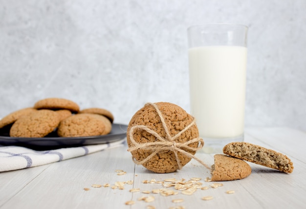 Oatmeal cookies and a glass of milk on a light background