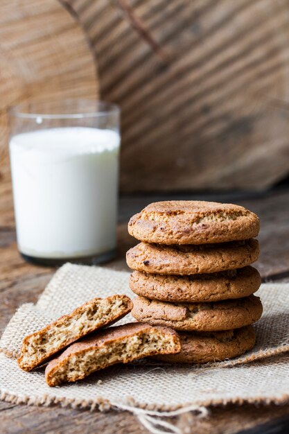 Oatmeal cookies and a glass of milk on wooden table