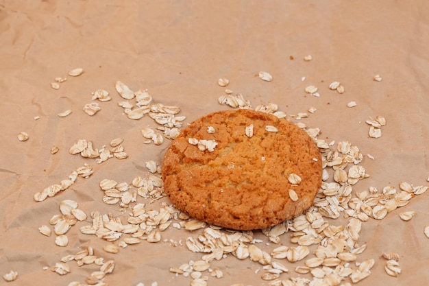 Oatmeal cookies and scattered oatmeal on crumpled paper background