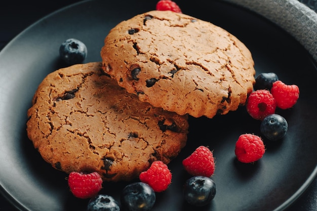Oatmeal cookies with berries on dark