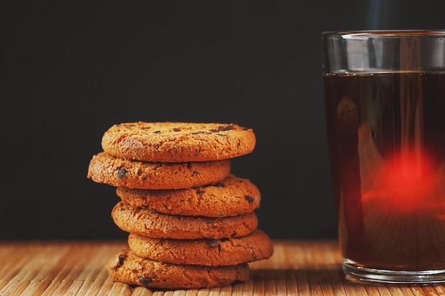 Oatmeal cookies with chocolate pieces and a mug of aromatic black tea 