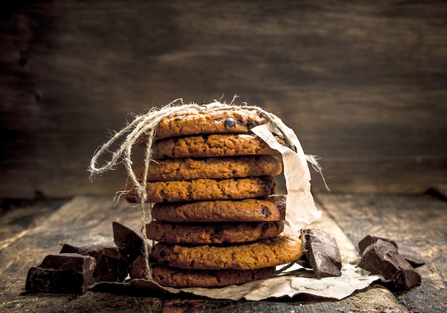 Oatmeal cookies with chocolate on a wooden background