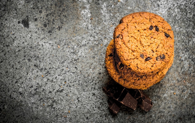 Oatmeal cookies with chunks of chocolate. On a rustic background.