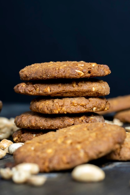 Oatmeal cookies with peanuts on a black wooden table