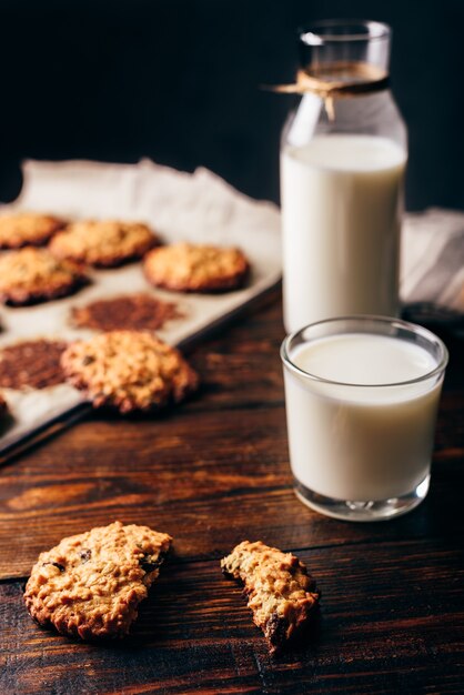 Oatmeal Cookies with Raisins and Glass of Milk for Breakfast. Some Cookies on Parchment Paper with Bottle