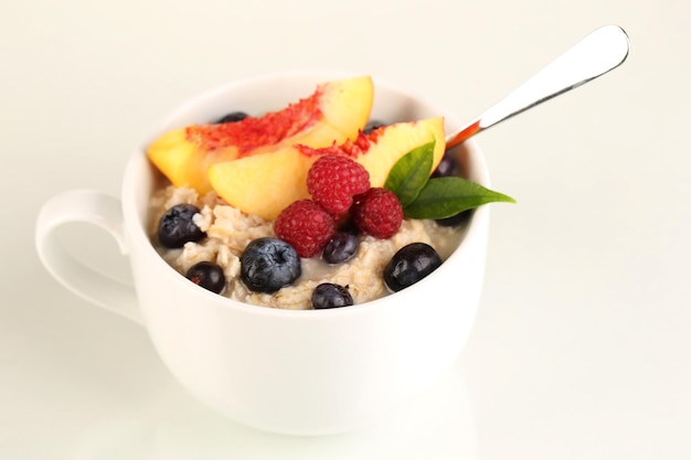 Oatmeal in cup with berries isolated on white