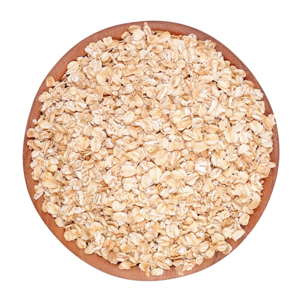 Oatmeal flakes in a wooden bowl isolated on a white background