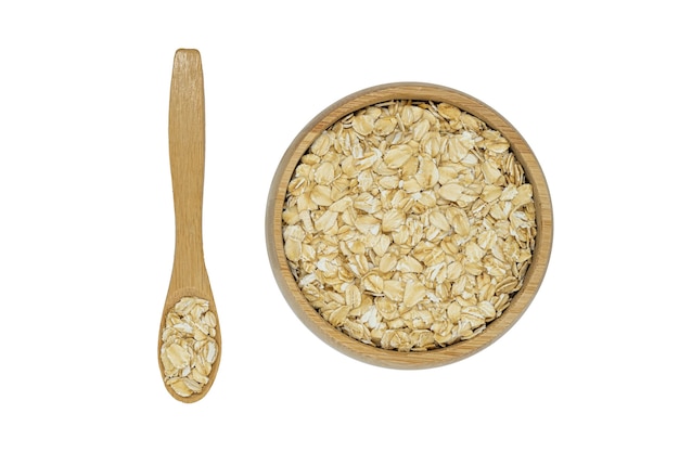 Photo oatmeal flakes in wooden bowl and spoon isolated on white