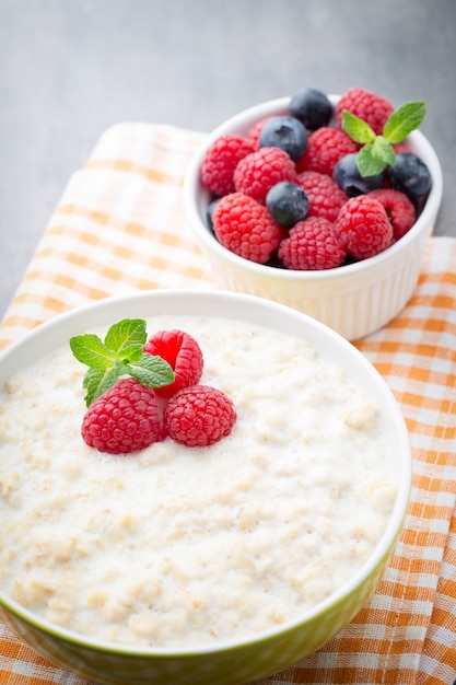 Oatmeal porridge in bowl with berries raspberries and blackberries.